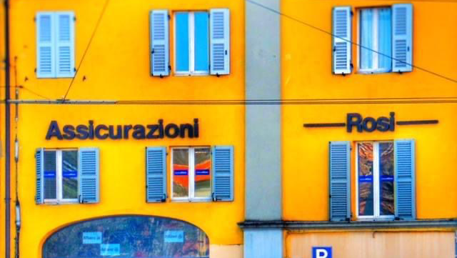 Facciata gialla dell'agenzia, con l'insegna Assicurazioni Rosi